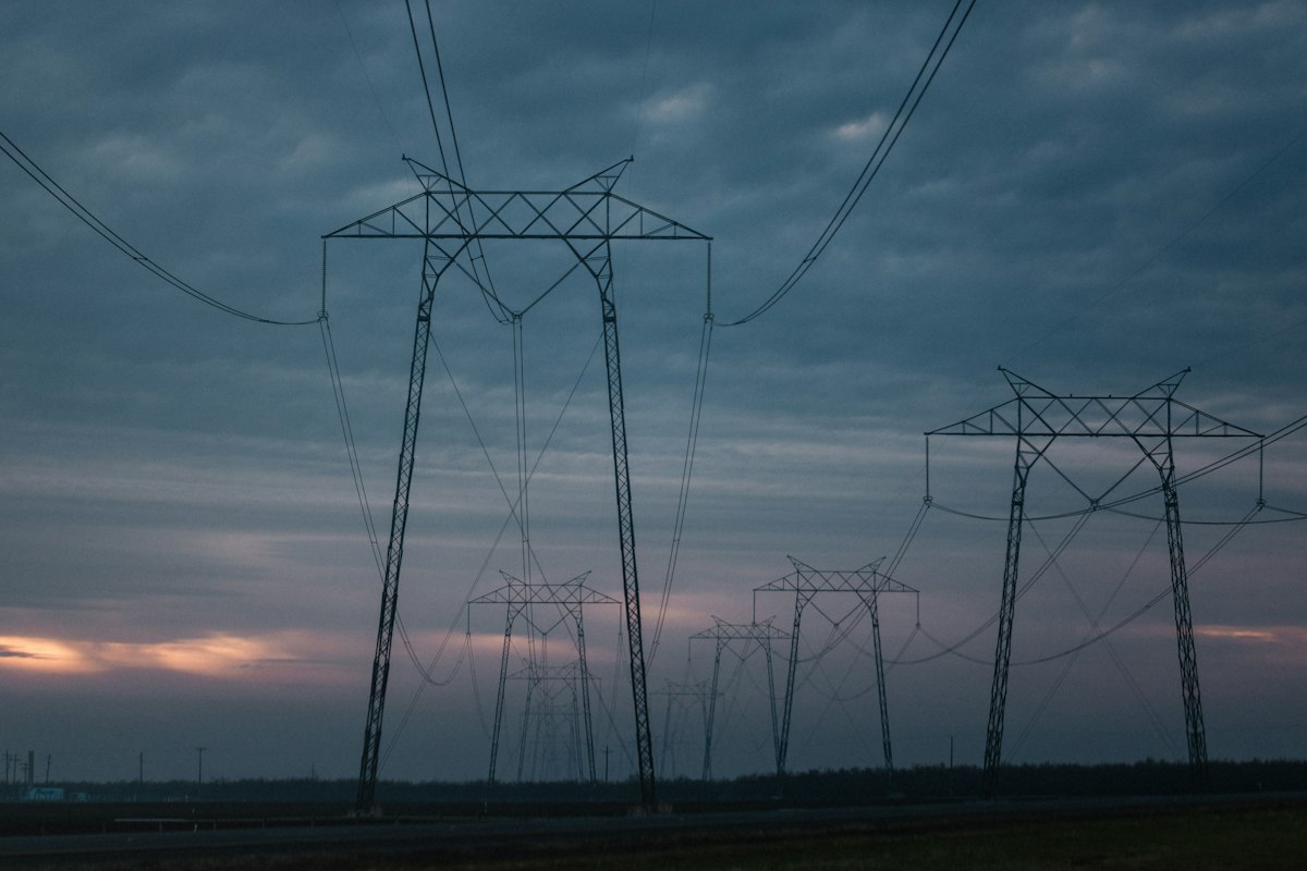 Electricity pylons beneath a warm evening sky